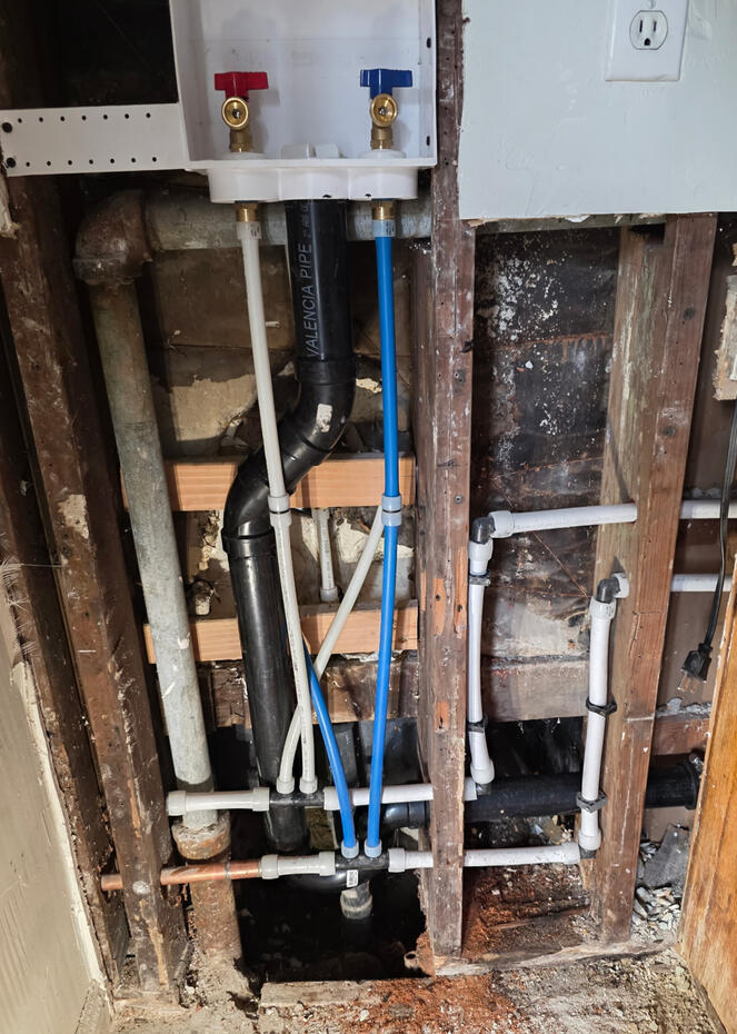 Residential plumbing installation showing plumbing lines and components during a home improvement project.